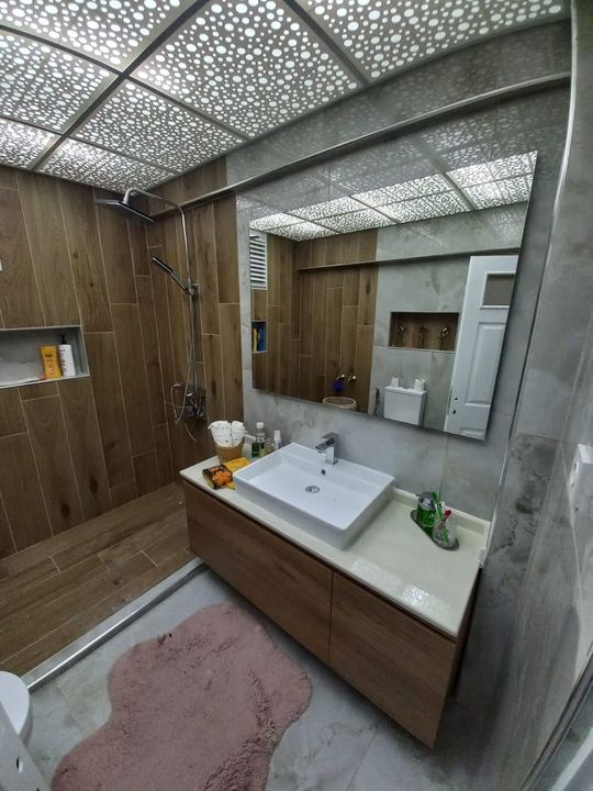 Banyo tadilatı sonrası lavabo dolabı, ayna ve mermer görünümlü duvar fayansı
